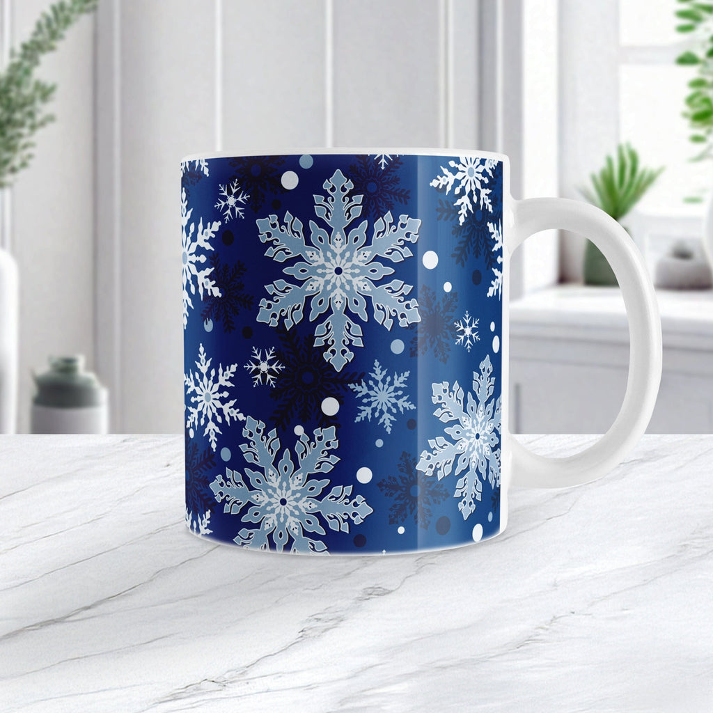 Mug with snowflake pattern on a blue background, placed on a white surface.